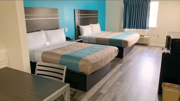 A hotel room with two beds, a desk, and a chair. - Motel 6 Houston, TX - Hwy 249 and Fallbrook (Houston)
