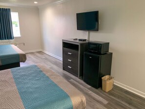 A hotel room with two beds, a TV, a microwave, and a small cabinet. - Motel 6 Houston, TX - Hwy 249 and Fallbrook (Houston)