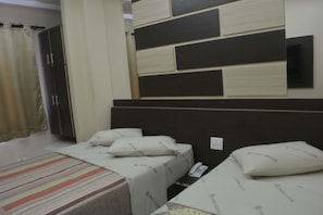 A hotel room with a bed, a bedside table, a telephone, and a wardrobe. - Hotel Calstar (Sao Paulo)