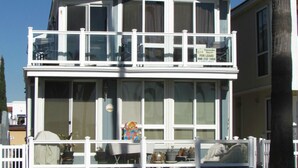 A two-story building with a balcony, a satellite dish, and a chimney. - 3 Bedroom Duplex with Ocean View (Newport Beach)