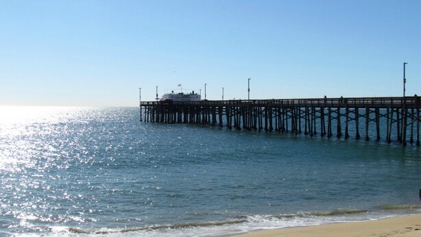 A pier extending into calm waters with a boat docked at the end. - 3 Bedroom Duplex with Ocean View (Newport Beach)