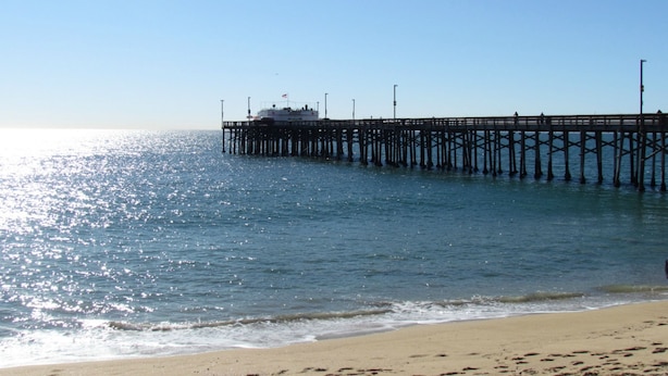 Un muelle se adentra en aguas tranquilas con un bote amarrado al final.