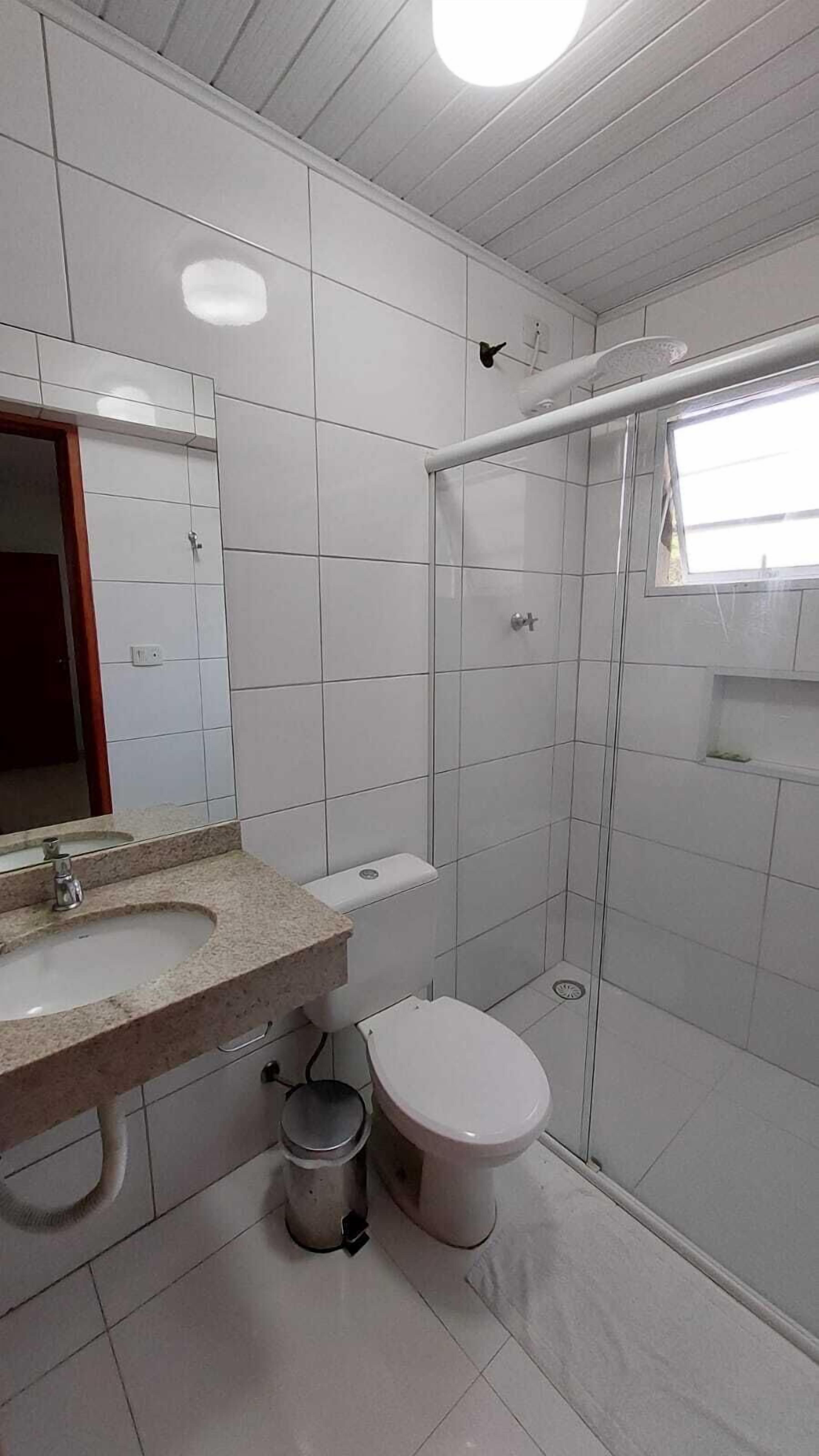 Un baño con lavamanos, inodoro y ducha.