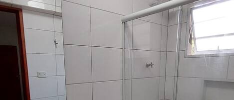 Un baño con lavamanos, inodoro y ducha.