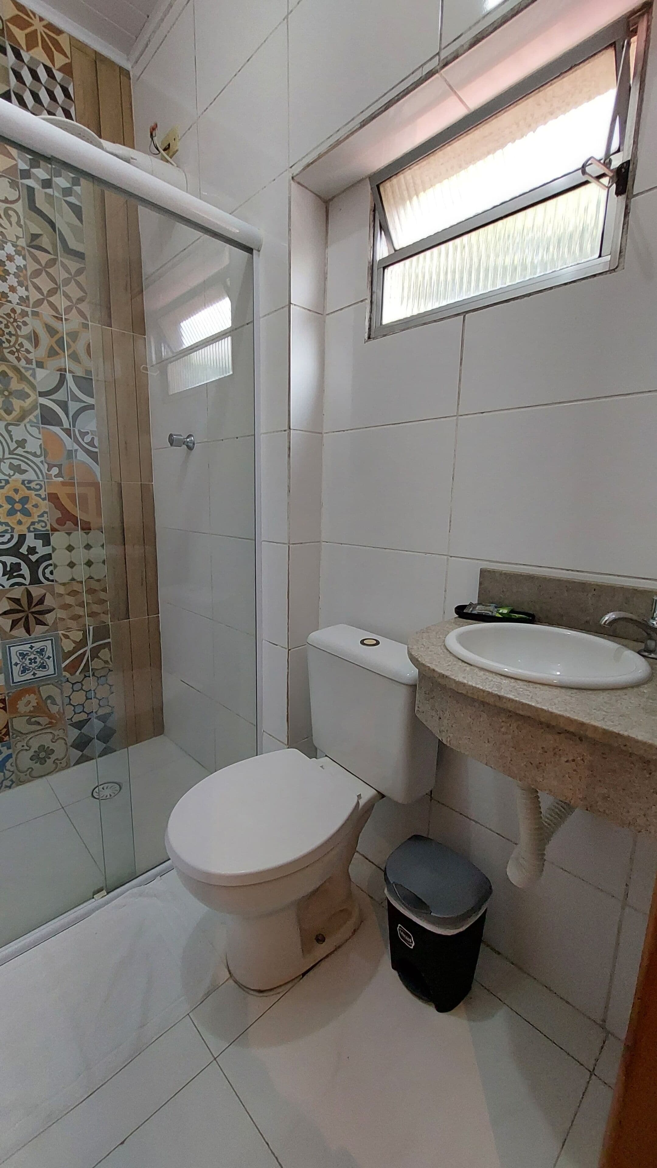 Un baño con inodoro, lavabo y zona de ducha.