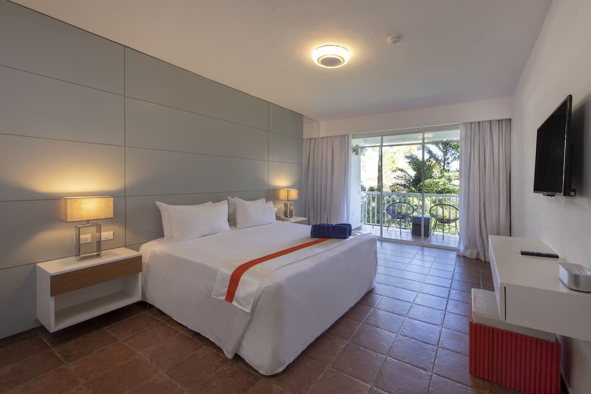 Une chambre d’hôtel moderne avec un grand lit, des lampes de chevet, un bureau et une télévision.