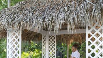 Relax in a serene setting under the thatched-roof gazebo, where a massage table awaits.