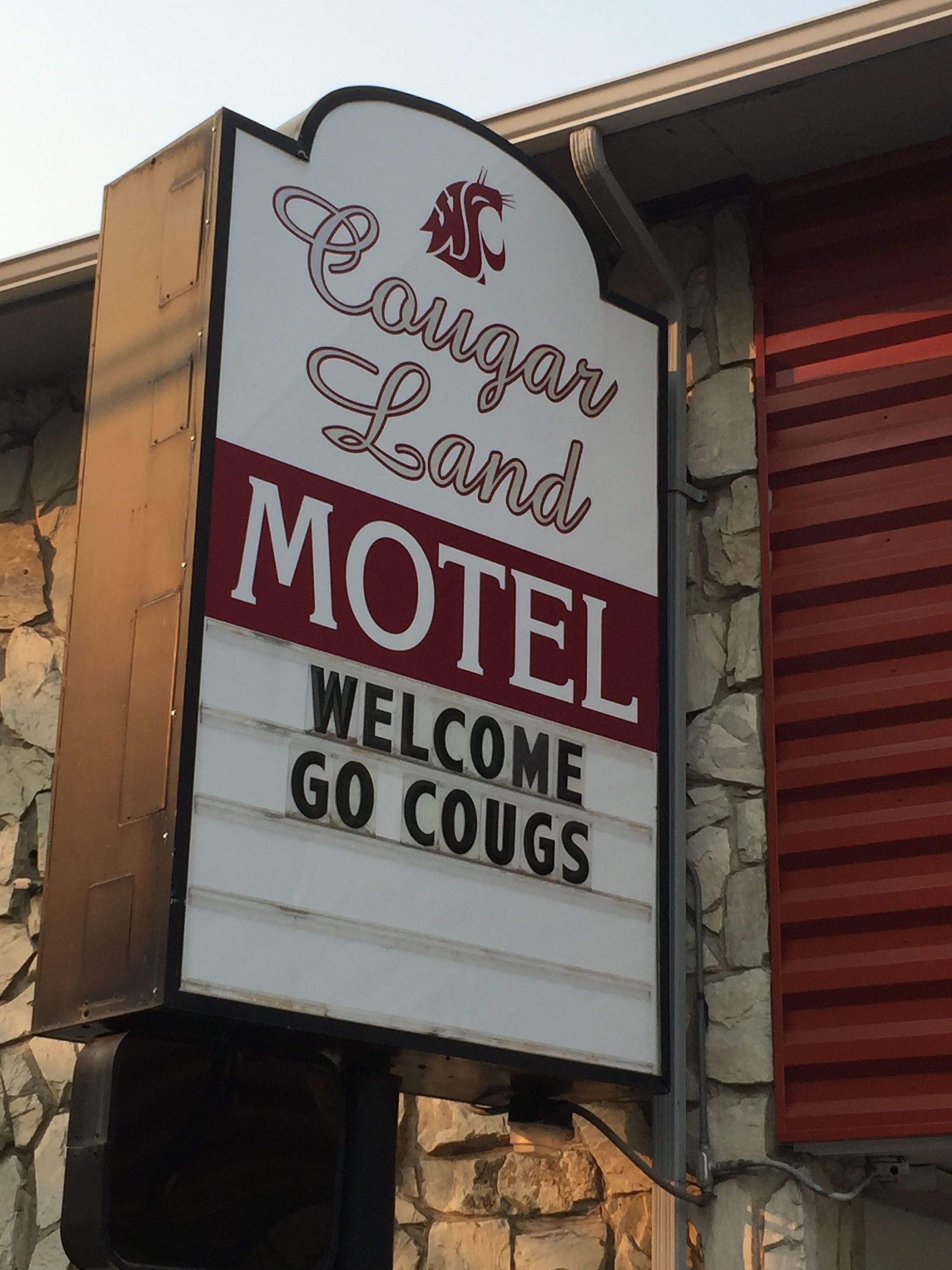 A motel sign with the text "Cougar Land Motel" and "Welcome Go Cougs".