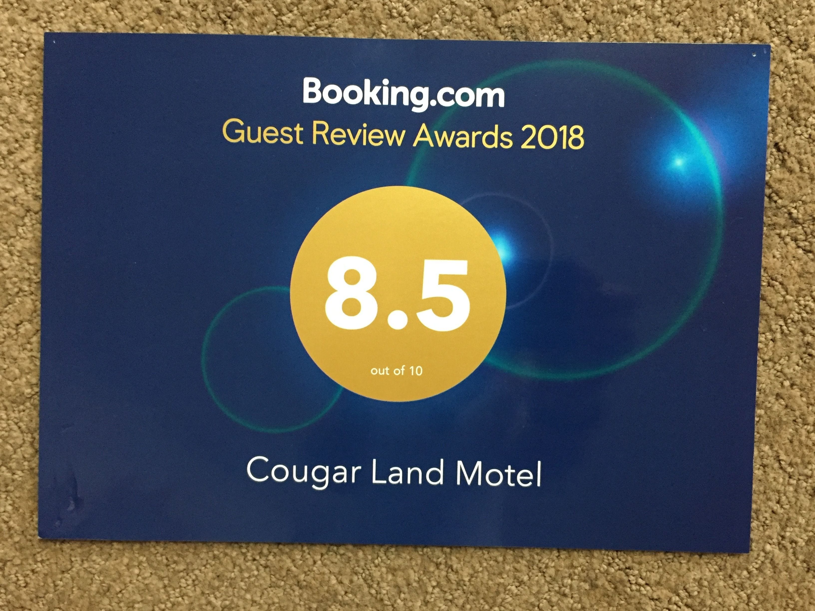Una placa para el Motel Cougar Land con una calificación de Premios Guest Review de Booking.com de 8.5 sobre 10.