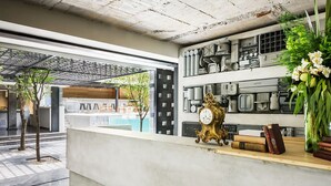 Un área de recepción de diseño moderno, con mostrador de recepción, un reloj y un jarrón decorativo con flores.
