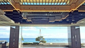 Un vaste espace intérieur doté d’une grande baie vitrée donnant sur la mer.