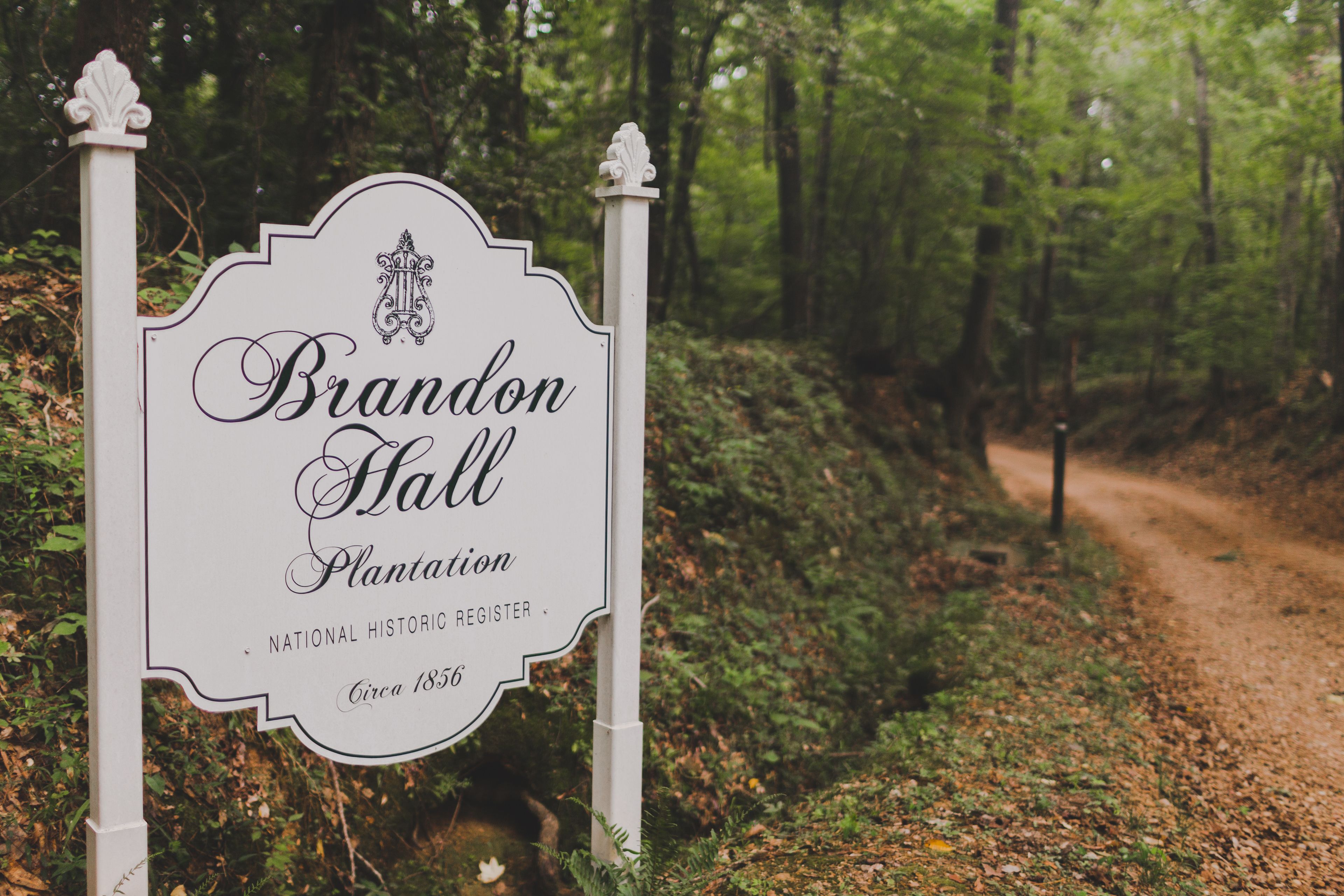 Skilt for Brandon Hall Plantation, en historisk bygning fra National Register of Historic Places, grundlagt omkring 1856, beliggende ved en skovsti.