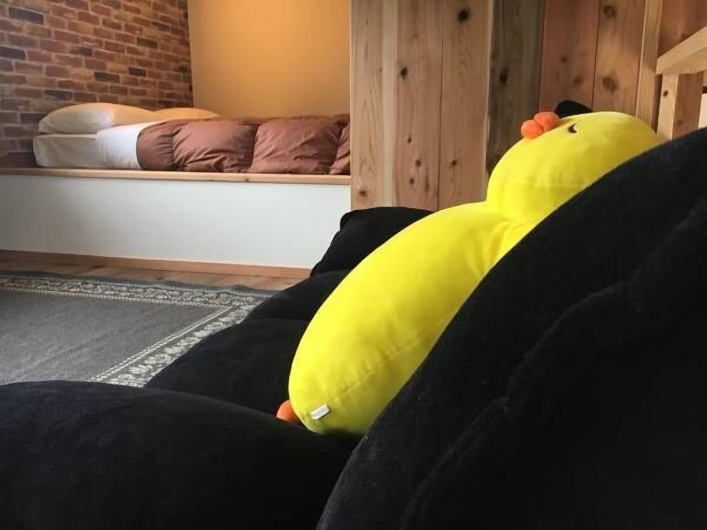 A room with a bed, a wooden headboard, and a brick wall.