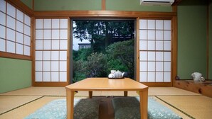 A traditional Japanese room with tatami flooring, a low wooden table, and shoji screens.