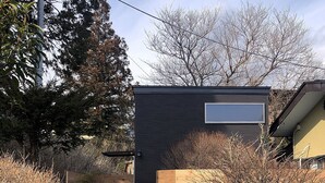 A modern building with a dark facade and a large window.