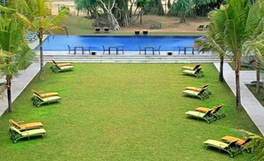 A pool area with lounge chairs arranged in a semi-circle around the pool.