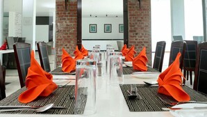 A conference room with a long table set for a meeting, surrounded by chairs.