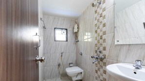 A bathroom with a toilet, shower, and sink. - Hotel Q Deck Rooms (Mumbai)