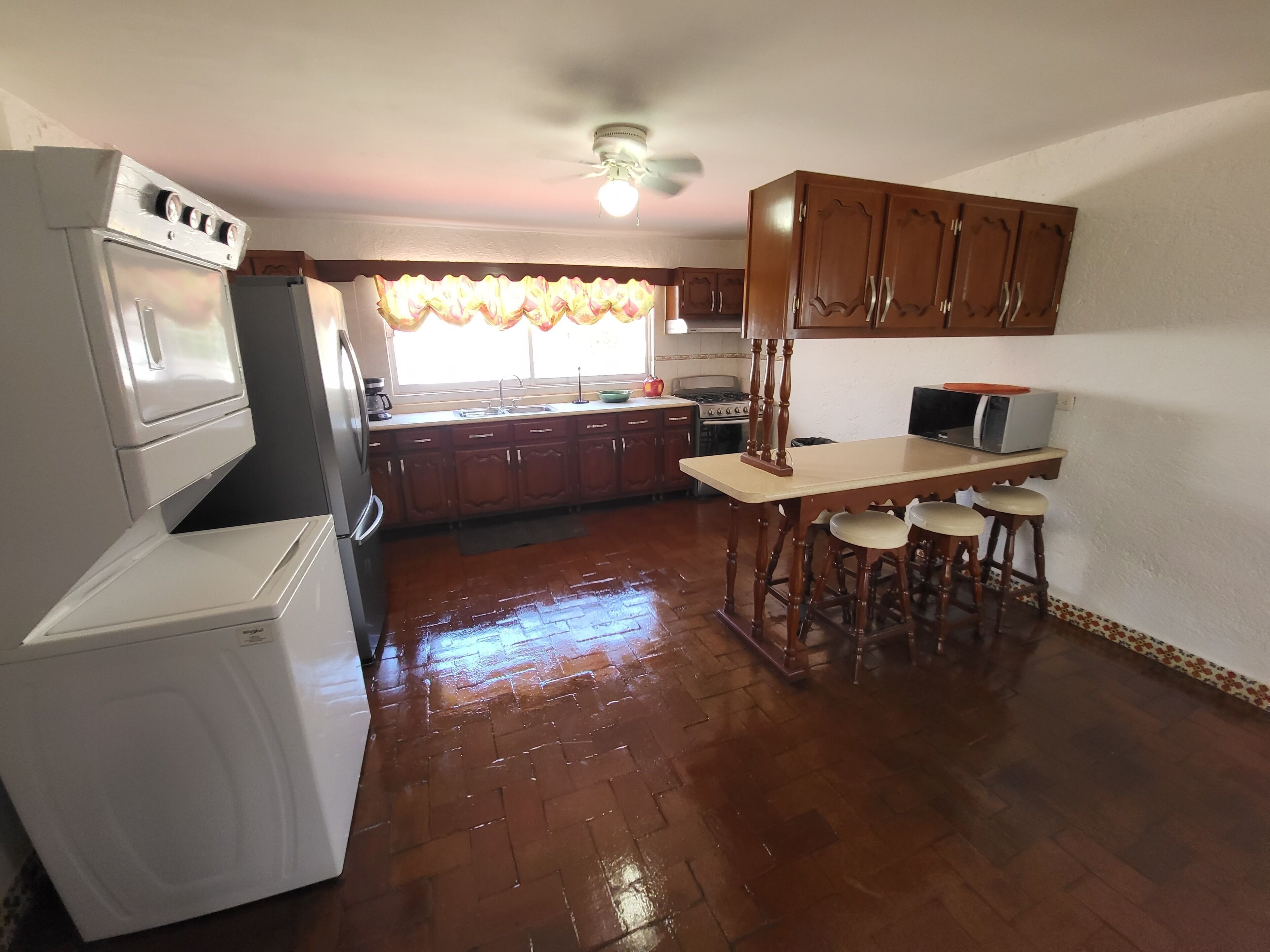 A kitchen with wooden cabinets, a white refrigerator, a stove, and a microwave.