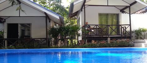 Alberca al aire libre, sombrillas en la alberca y camastros