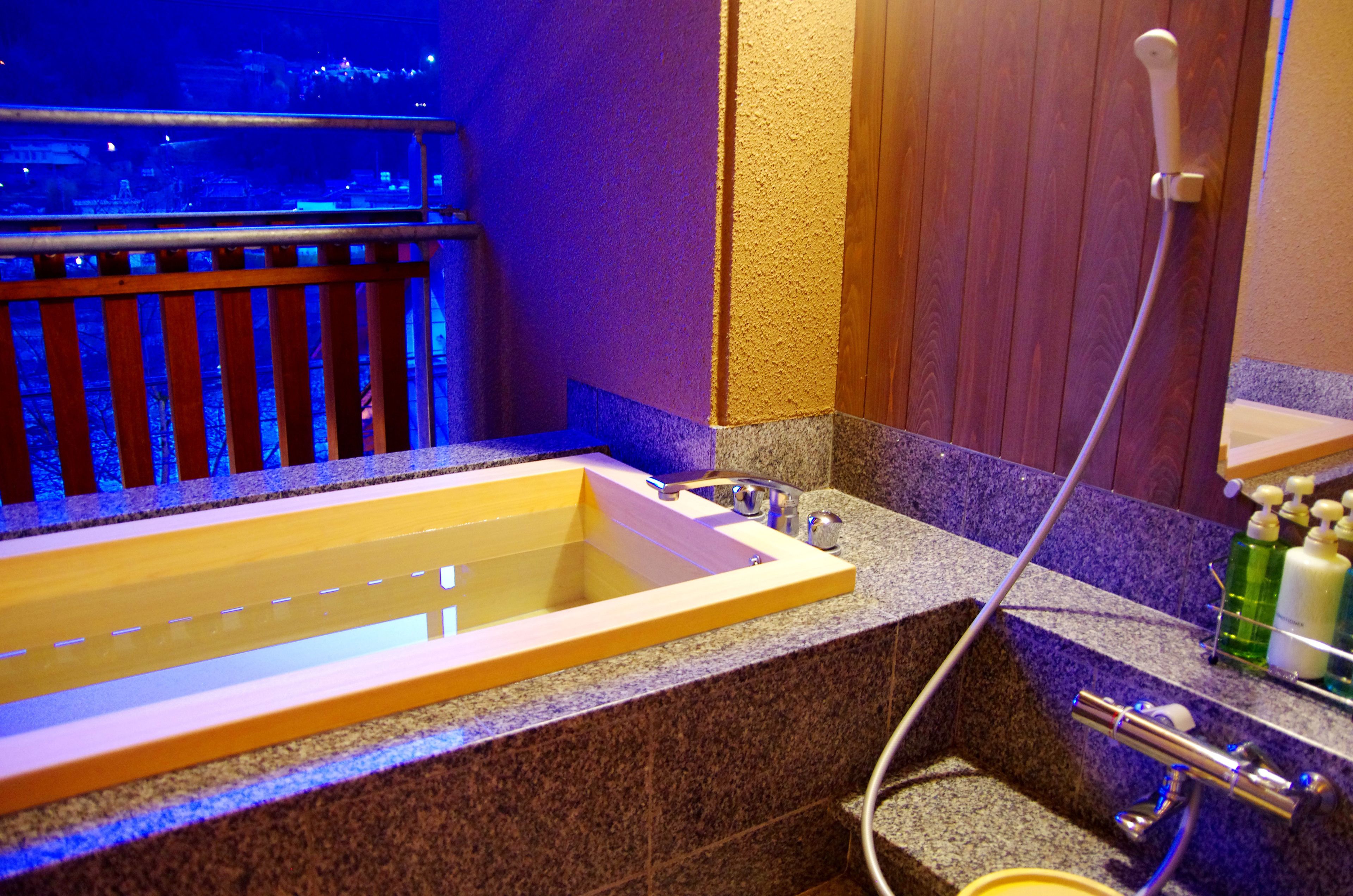 A bathroom with a bathtub, a shower, and a vanity with toiletries.