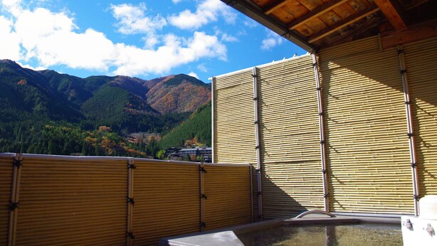 Un onsen japonais traditionnel, avec des portes coulissantes en bois et une vue sur les montagnes.