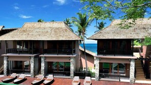 A resort with two-story buildings, a pool area with lounge chairs, and a view of the ocean. - Koh Tao Beach Club (Koh Tao)