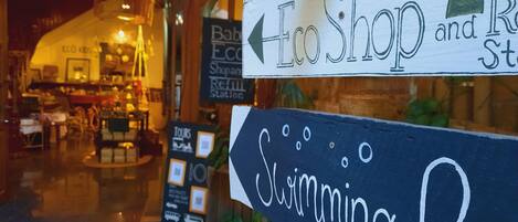 A storefront with signs for 'Eco Shop' and 'Swimming Pool'.