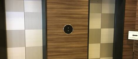 Two elevator doors with a digital display indicating floor numbers.