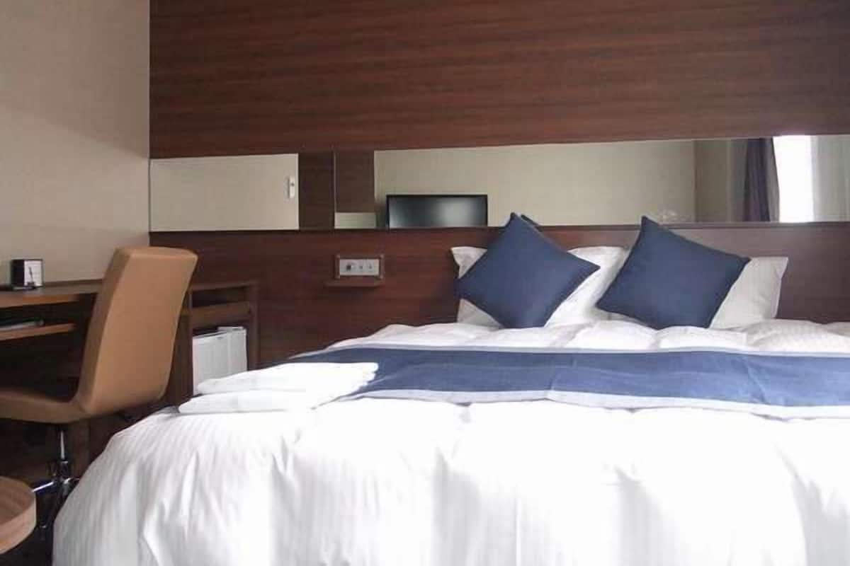 Escritorio, cortinas blackout y tabla de planchar con plancha