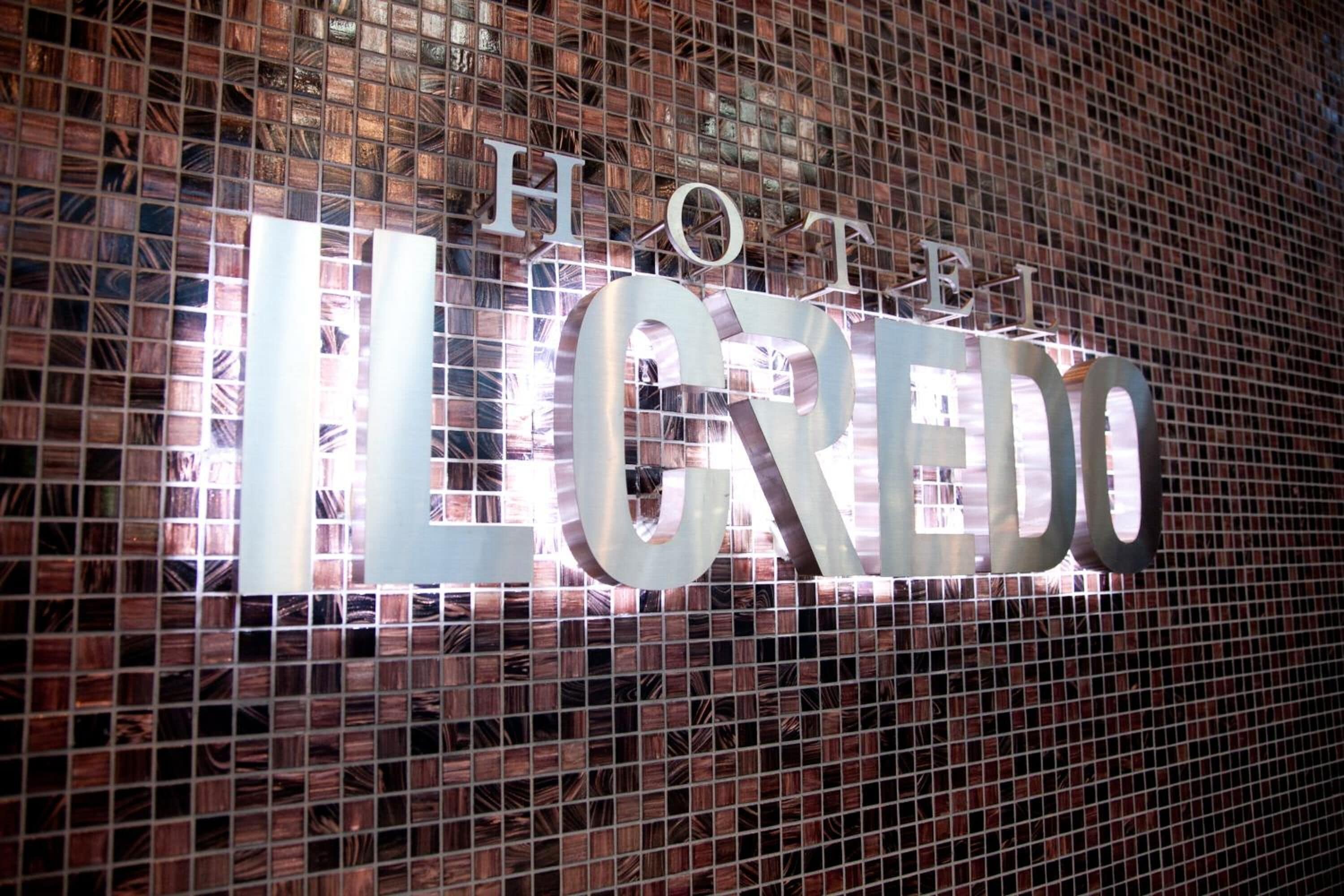 A hotel sign with the name "HOTEL IL CREDO" in large letters.