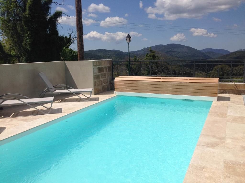 Una piscina al aire libre, sillones reclinables de piscina