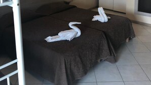 Une chambre d’hôtel avec un lit, une armoire et une lampe fixée au mur.