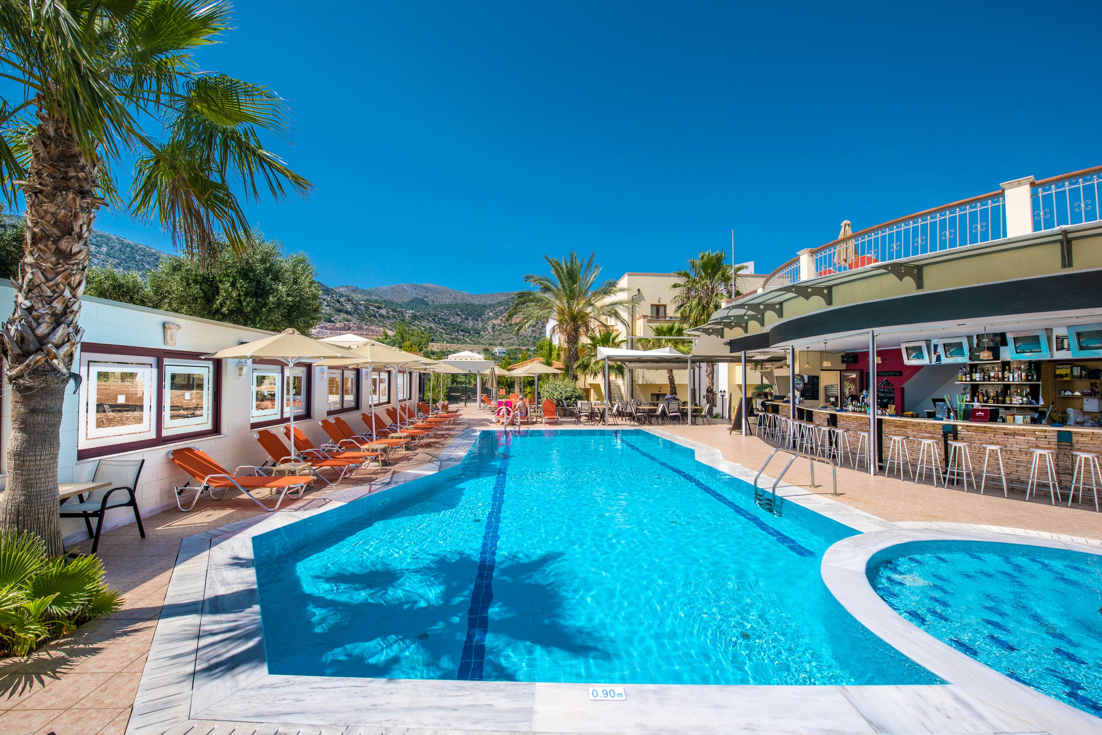 Una piscina al aire libre, sombrillas, tumbonas