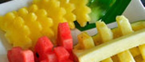 A plate with yellow and red food items, possibly fruits or vegetables.
