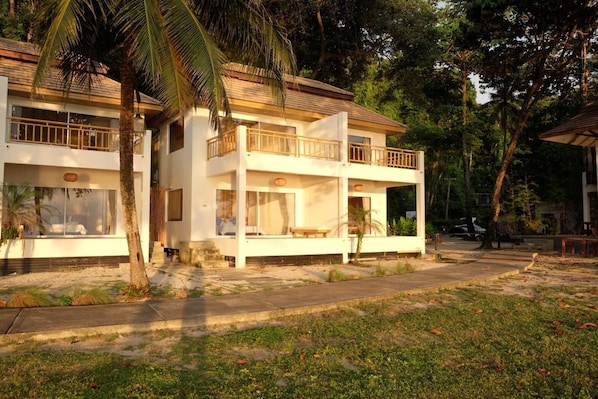 A two-story building with balconies, a covered outdoor seating area, and a sandy ground. - Siam Beach Resort (Ko Chang)