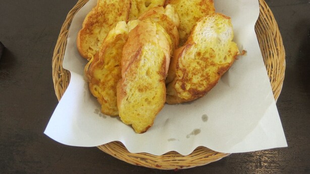 A basket of golden-brown bread rolls on a table. - Siam Beach Resort (Ko Chang)