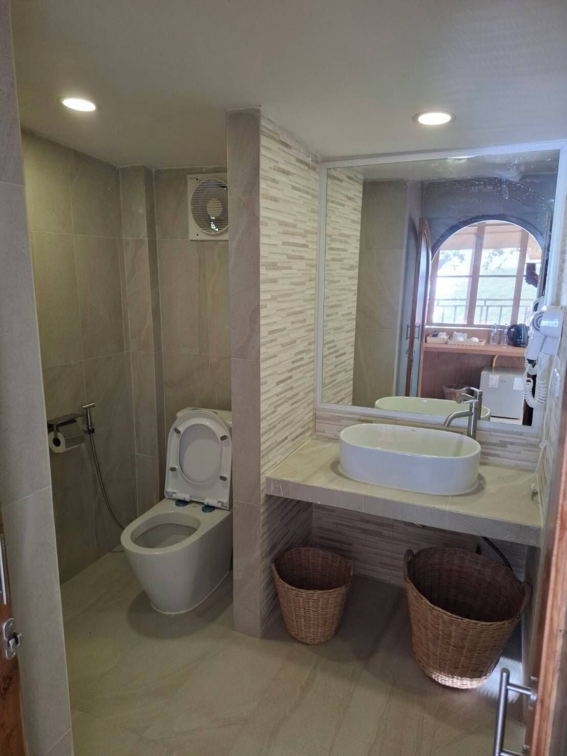 Een moderne badkamer met toilet, wastafel en douche.