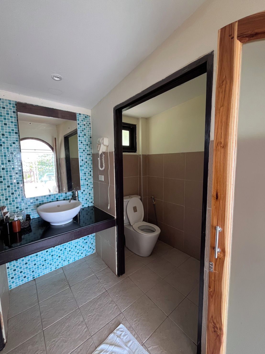 A bathroom with a white sink, a mirror, and a toilet.