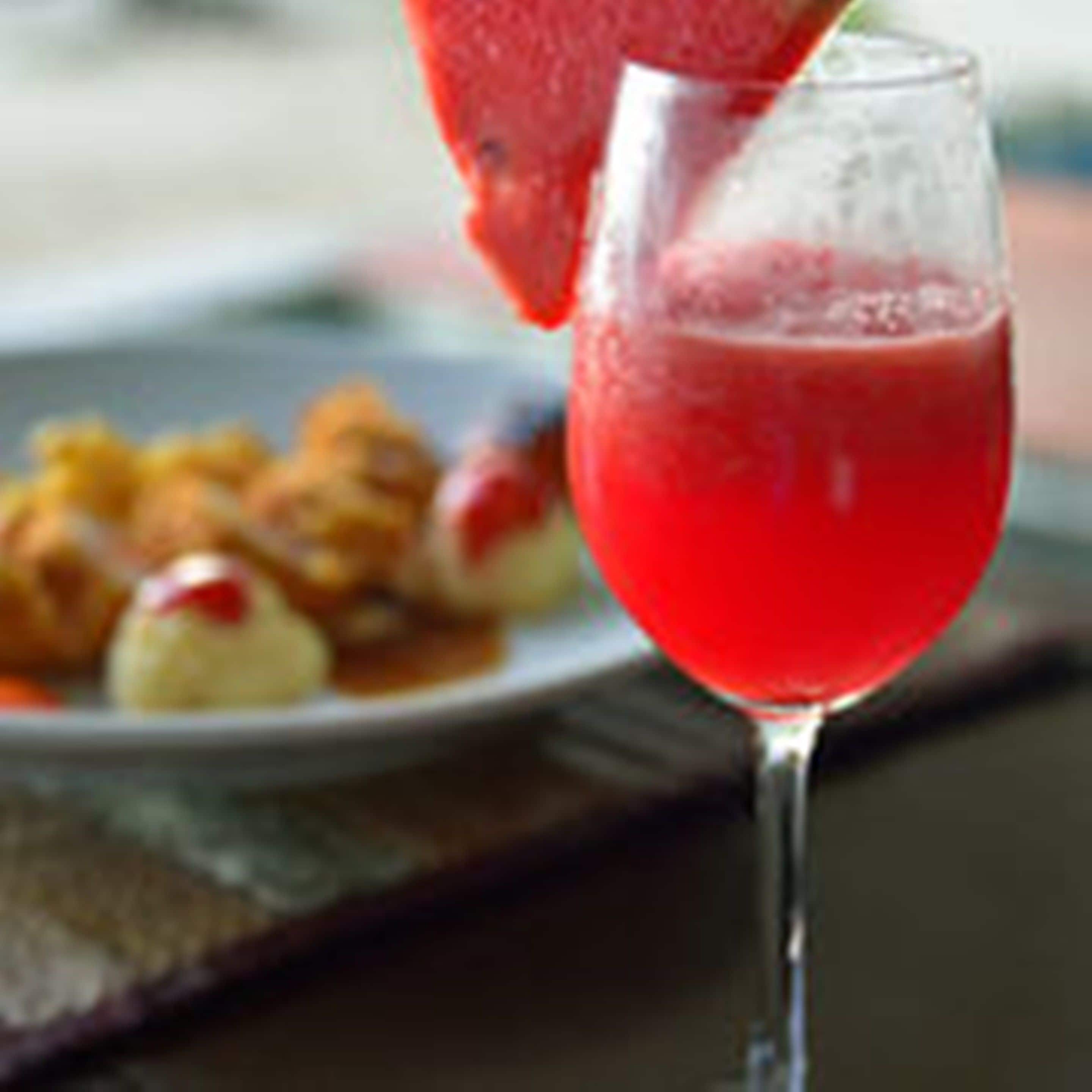A glass of red beverage being poured.