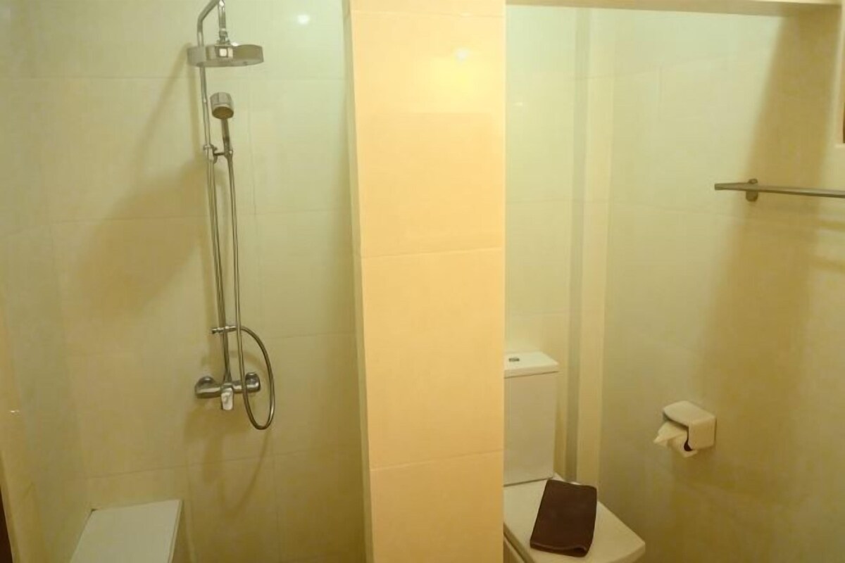 A bathroom with a shower, toilet, and a towel rack.