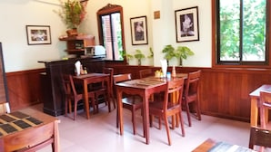 A dining area with wooden furniture, a table, chairs, and a counter.