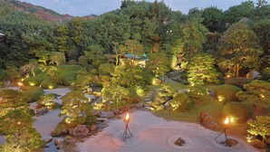 A traditional Japanese garden with a torii gate, koi ponds, and well-manicured trees.