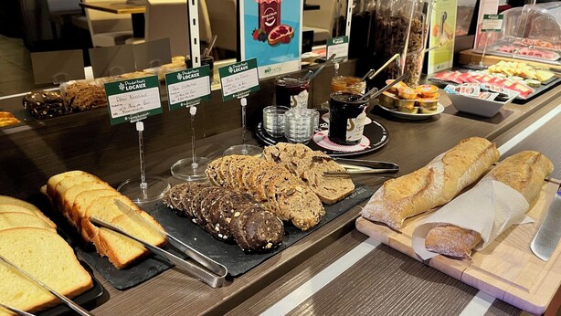 Un buffet de petit-déjeuner proposant une variété de pains, de viennoiseries et de tartinades.
