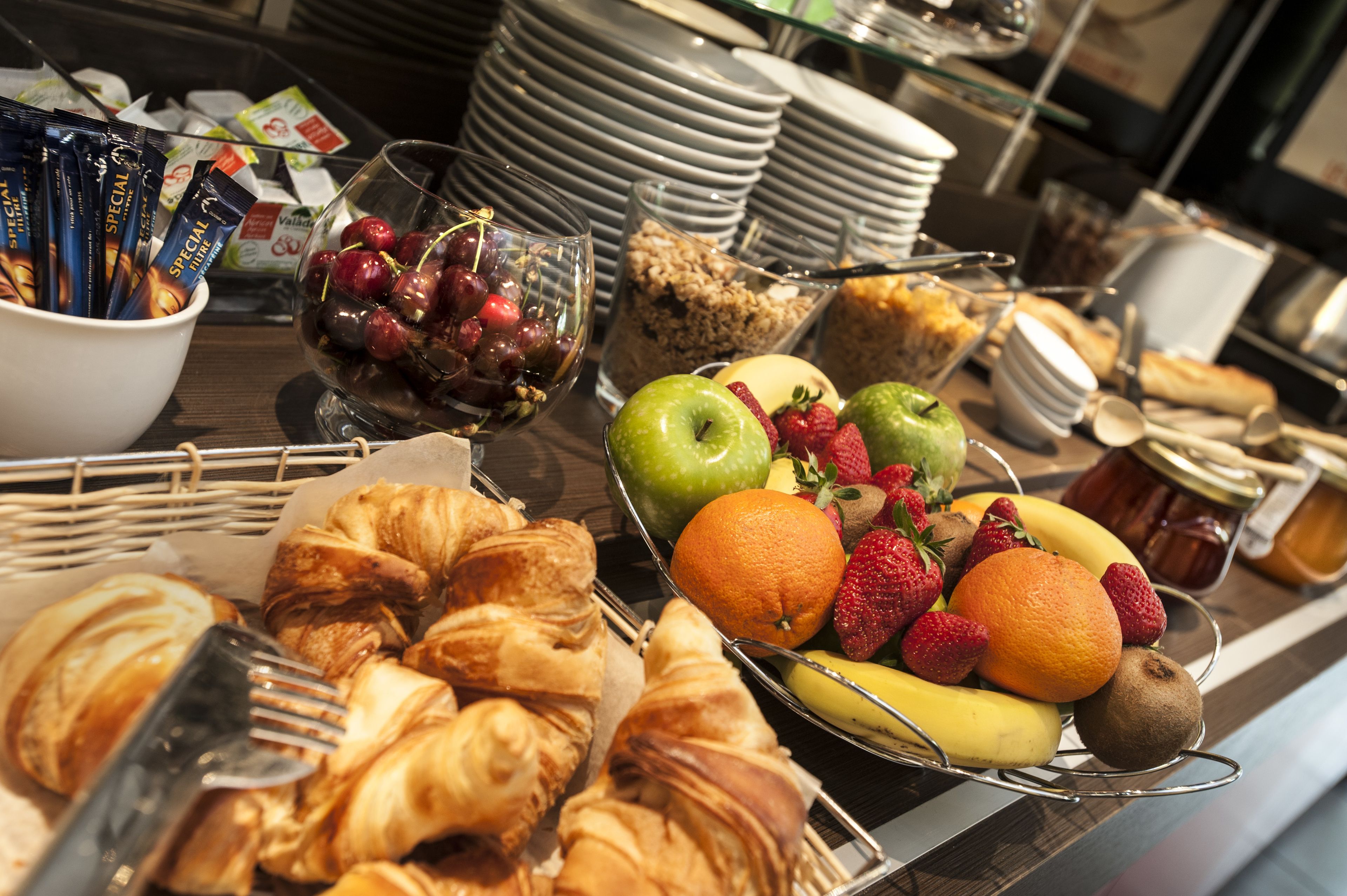 Ein reichhaltiges Buffet mit verschiedenen Speisen, darunter Obst, Gebäck und Soßen.
