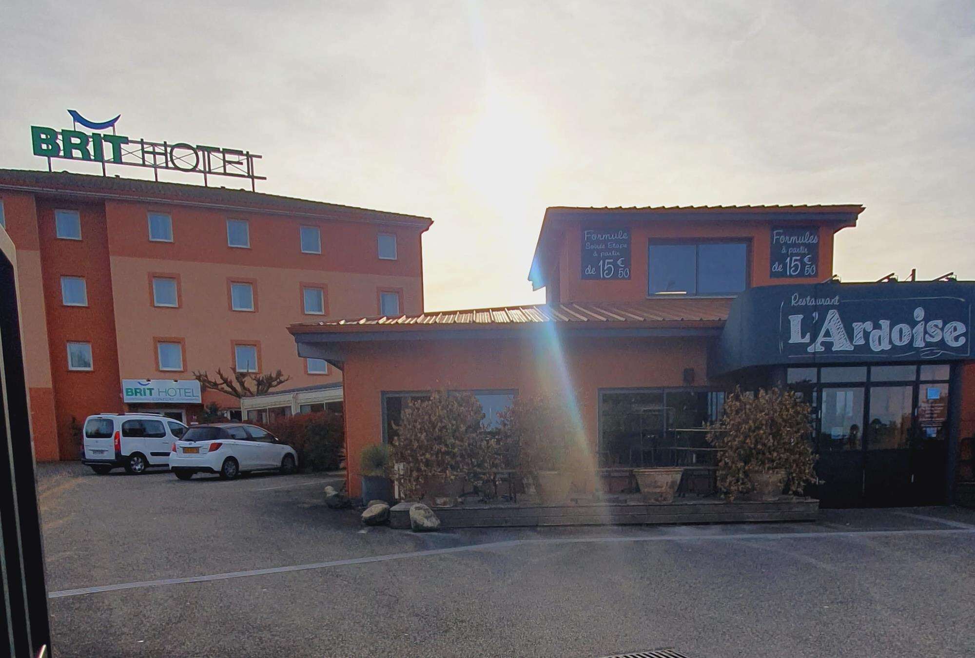A hotel with a sign reading "BRIT HOTEL" and a restaurant named "L'Azais."