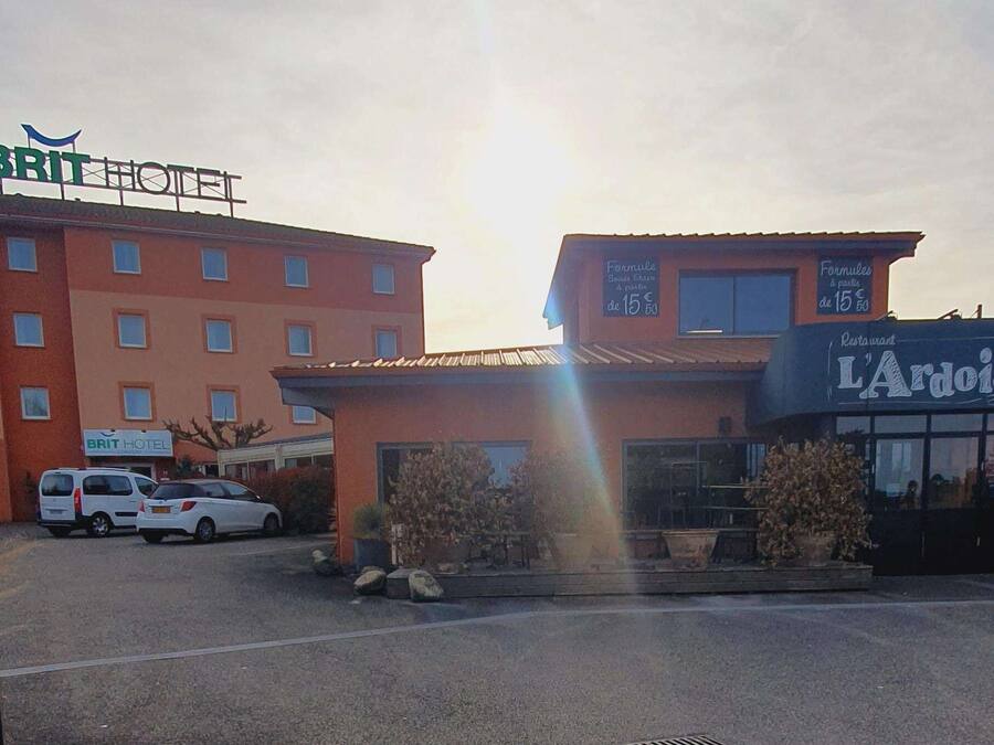 A hotel with a sign reading "BRIT HOTEL" and a restaurant named "L'Azais."