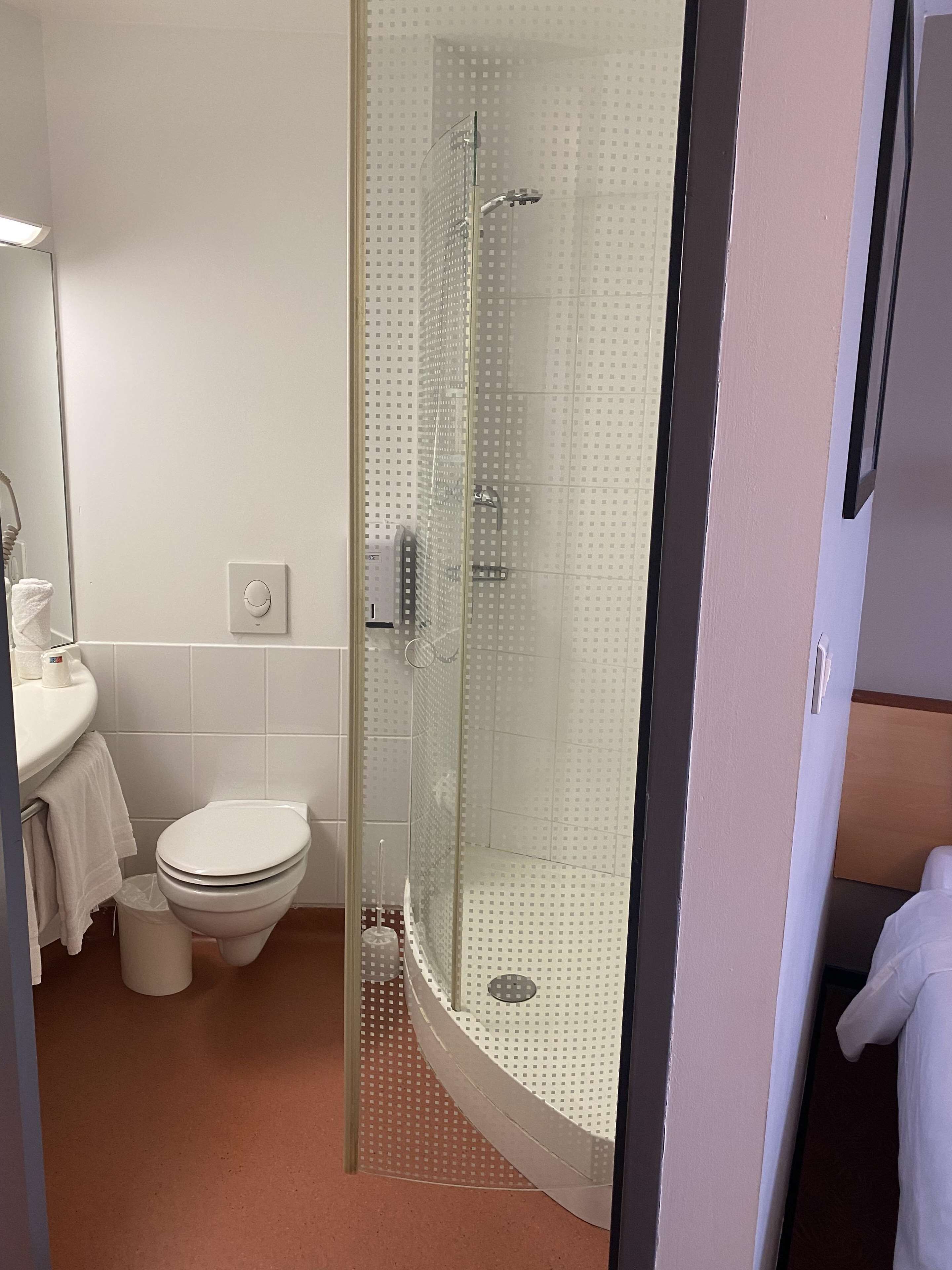 Een badkamer met toilet, wastafel en een douchecabine.