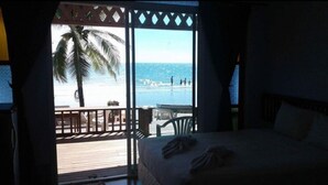 Habitació amb llit i vista a la platja.