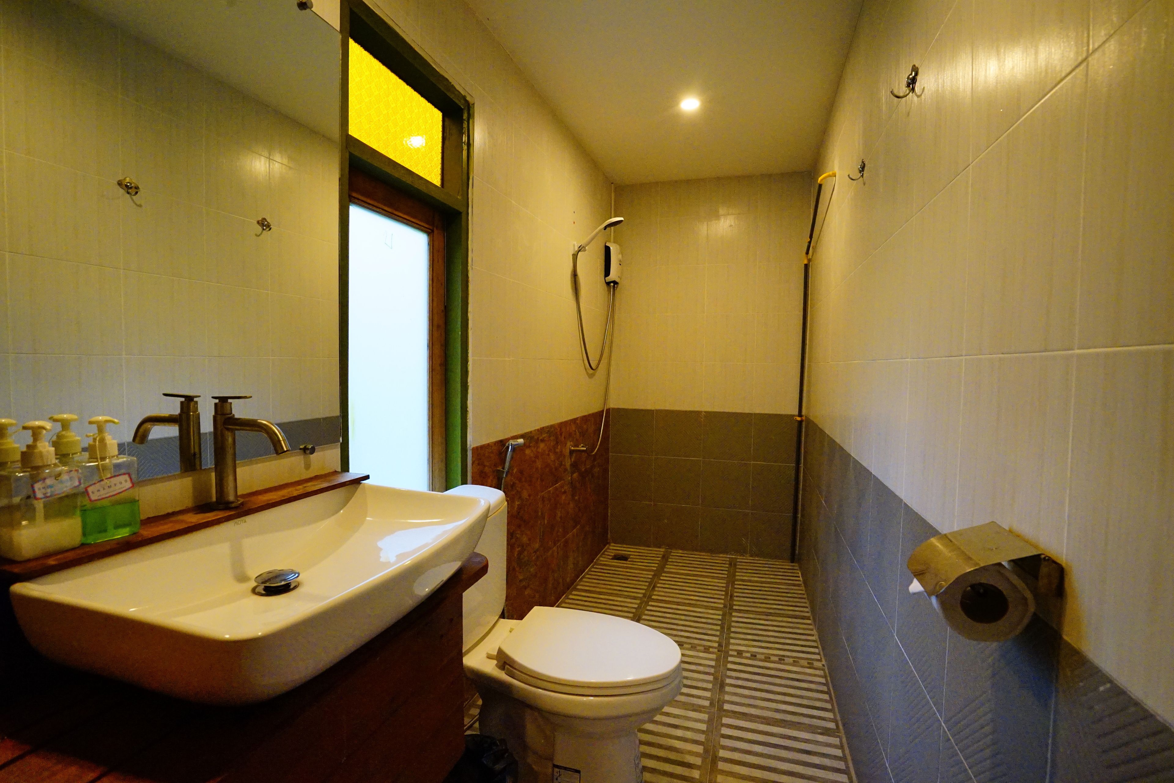 Une salle de bain équipée d’un lavabo, de toilettes et d’une douche.